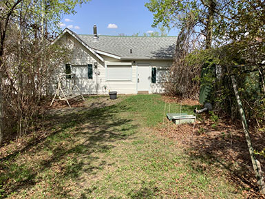 a white farmhouse with a bench swing in the yard